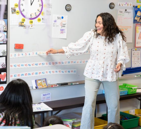 Wesley Schantz stands with students besides international flags in Gonzaga's Hemmingson Center. 